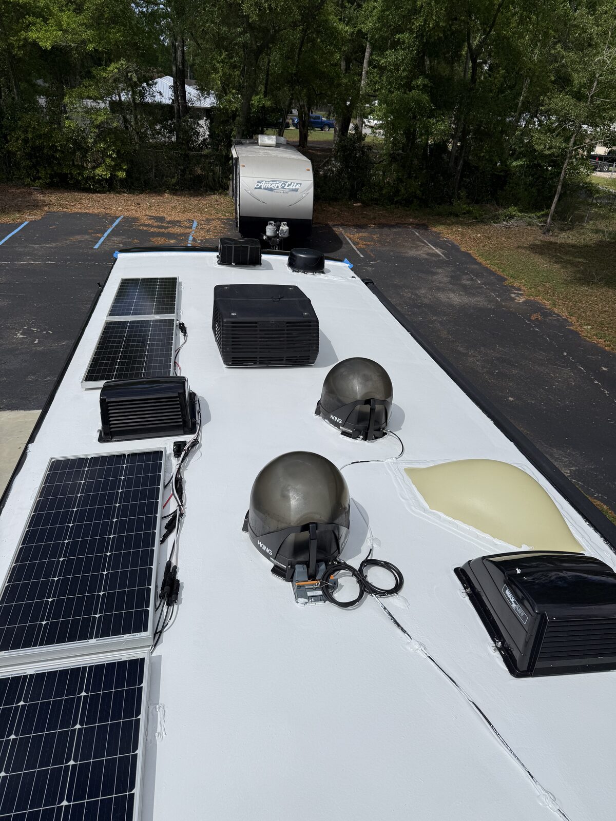Motorhome roof with solar panels, vents and air conditioner after sealing