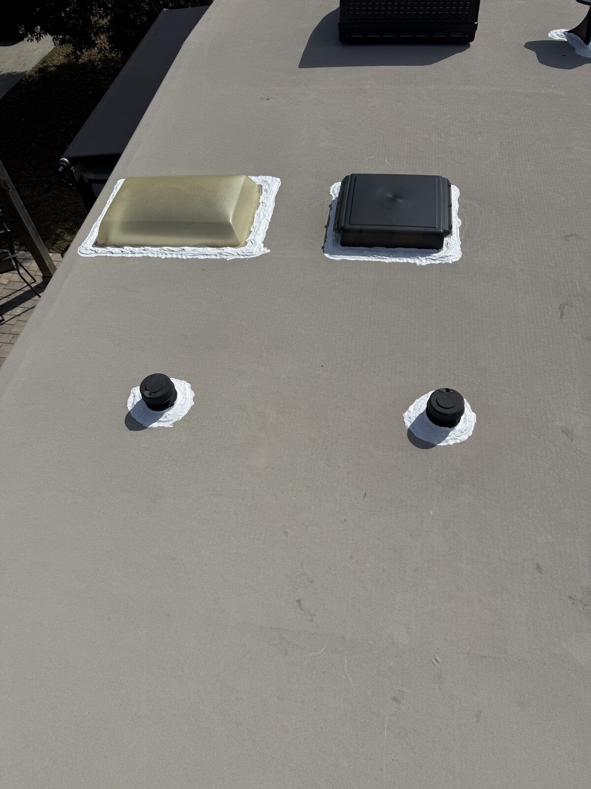 Completed RV roof with resealed skylight, vent and plumbing penetrations